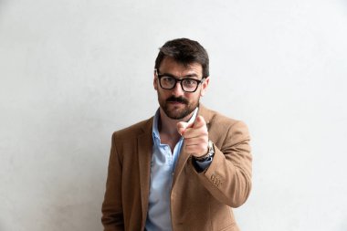 Gülümseyen Genç İşadamı, gözlük takmış, Gri Duvara Karşı Kamera 'ya fotokopi uzayı ile bakıyor. Resmi Takma Portrede Başarılı İş İnsanı