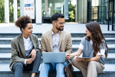 Bir grup başarılı genç iş adamı, pazarlama ve motivasyon liderleri, ofis binasının önünde durup çalışanlarla bir toplantı öncesinde danışmanlık yapıyorlar. Şirket konseptinde insan kaynakları iletişimi