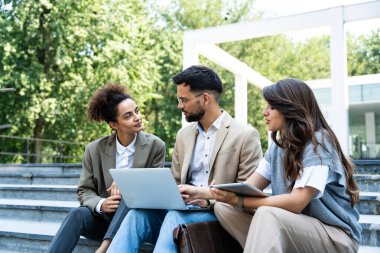 Bir grup başarılı genç iş adamı, pazarlama ve motivasyon liderleri, ofis binasının önünde durup çalışanlarla bir toplantı öncesinde danışmanlık yapıyorlar. Şirket konseptinde insan kaynakları iletişimi