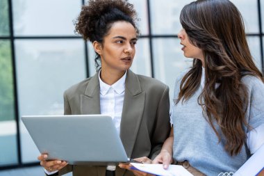 İki iş adamı, çalışan kadınlar, gülümseyen ve birbirlerine bakan biri dizüstü bilgisayar, diğeri ise istatistiksel planlar ve belgeler. Ofis binasının dışında tartışan iki iş arkadaşı..