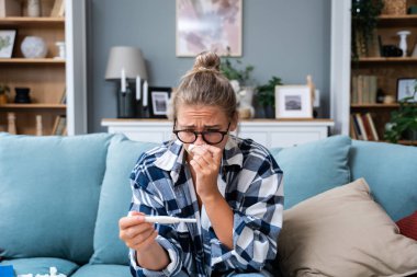 Bekar, üzgün bir kadın, evdeki oturma odasındaki koltukta oturan hamile ya da değil, kadın, pozitif ya da negatif testlerden şikayetçi..