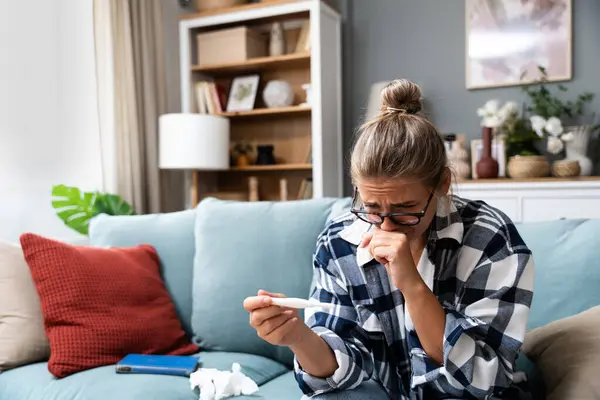 Bekar, üzgün bir kadın, evdeki oturma odasındaki koltukta oturan hamile ya da değil, kadın, pozitif ya da negatif testlerden şikayetçi..