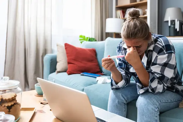 Bekar, üzgün bir kadın, evdeki oturma odasındaki koltukta oturan hamile ya da değil, kadın, pozitif ya da negatif testlerden şikayetçi..