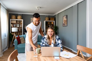 Genç, erkek arkadaş desteğiyle evde dizüstü bilgisayarla çalışan bağımsız bir kadın. İş çifti küçük çevrimiçi şirket sahipleri, küresel pazar talebi durumunu kontrol ederek internette araştırma yapıyorlar.