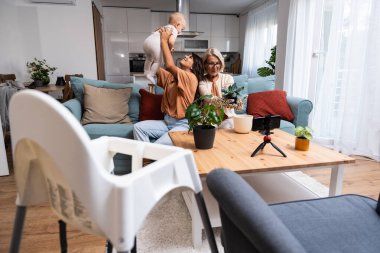 Anneanne ve bebek torun birlikte çiçek nakleder, humusu daha büyük bir saksıda değiştirir, evde güzel vakit geçirir ve eğleniriz. Üç kadın nesil.