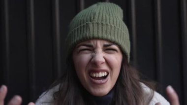 Genç kızgın kadın bağırıyor ihanete uğramış, aldatılmış ve hayal kırıklığına uğramış hissediyor. Kadın kameraya negatif duygular ve agresif davranışlarla bakıyor. Gençlik bunalımı