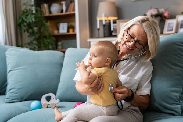 Büyükannesi Emekli Doktor Steteskop Kullanıyor Torunu Torunu Genç Bebek Ciğerleri Telifsiz Stok Fotoğraflar