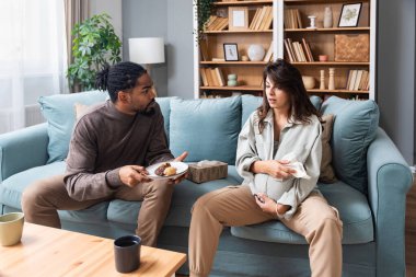 Genç adam gelecekteki babası hamile kız arkadaşına hamileliği boyunca yardım ediyor ve ona yardım ediyor. Kanepede oturan bir çift, kocası bebeğini taşıyan sinirli karısını rahatlatıyor..