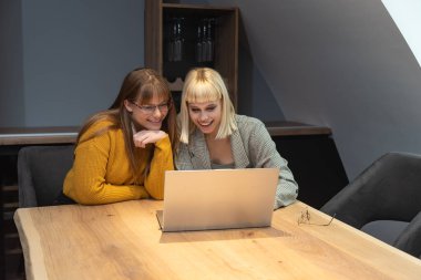 İki genç serbest çalışan iş kadını dizüstü bilgisayarda ürün stratejisi uzmanı olarak çalışıyor. Yabancı bir şirket için internet üzerinden internet üzerinden yurtdışı çalışan bir kadın web geliştiricisi.