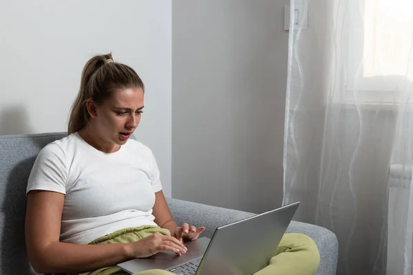 Simple living. Young freelance business woman working at home on laptop as product strategy expert. Female expatriate remote work on internet on computer online for foreign company as web developer.