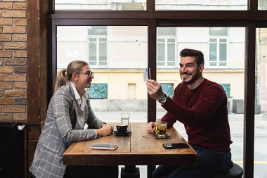 Restorandaki çift banka kartını gösterip çalışanı arıyor. Barda kız arkadaşıyla beraberken, bir garsona erişimi olmayan bir kredi kartıyla ödeme yapan bir adam..