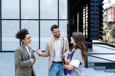 Bir grup genç iş adamı, ofis binasının önünde işverenle görüşmek için çağrılmayı bekleyen iş adayları. İş adamları ve iş kadınları insan kaynaklarını bekliyor.