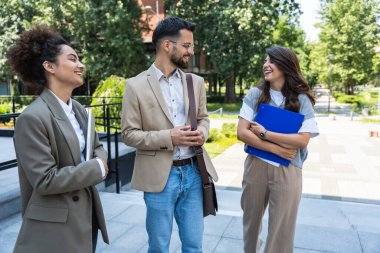 Bir grup genç iş adamı, ofis binasının önünde işverenle görüşmek için çağrılmayı bekleyen iş adayları. İş adamları ve iş kadınları insan kaynaklarını bekliyor.