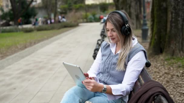 Mladá Podnikatelka Sedící Parku Lavičce Pracující Digitálním Tabletu Poslouchající Hudbu — Stock video