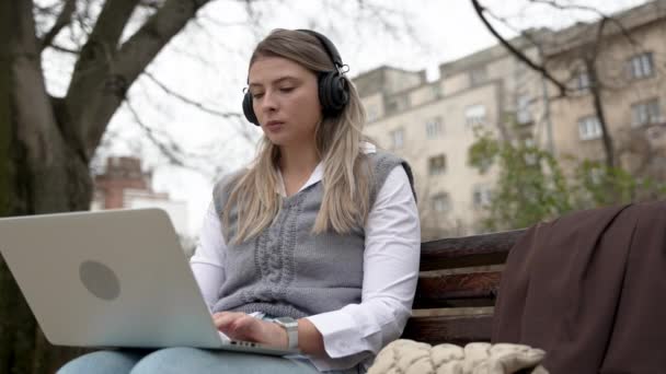 Jonge Zakenvrouw Het Park Bank Werken Aan Laptop Computer Luisteren — Stockvideo