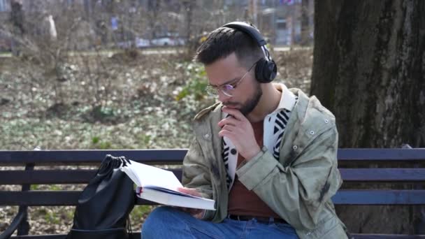 Genç Yakışıklı Hippi Serbest Çalışan Ceketli Dışarıda Otururken Kitap Okuyan — Stok video