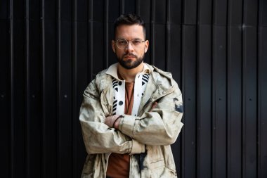 Genç, modaya uygun sinirli adam dışarıda tek başına duruyor, kameraya öfkeyle bakıyor. Kollarını kavuşturup intikam almayı düşünen öfkeli bir erkek..