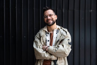 Genç hippi serbest iş adamının dışarıda durup gülümseyerek kameraya bakmasına yakın dur. Bin yıllık başarılı erkek nesli z gözlüklü, hayatından memnun.