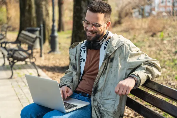 Young freelance business hipster man is work on new project outside on laptop computer. Businessperson working and telecommuting outdoors on fresh air, global business expert in economy like freedom