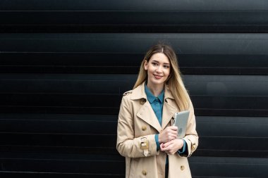 Ofis binasının önünde duran başarılı iş kadınının portresi. Eğitimli bağımsız kadın takım lideri iş adamı siyah duvara karşı poz veriyor..