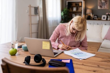Genç kadın ekonomist ekonomi uzmanı iş yeri iş stratejisi istatistiklerinin internet üzerinden sunumunda yönetici ya da öncü internet ile bilgisayardan video görüşmesi yapıyor.
