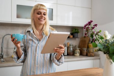 Genç bir kadın sabah rutini, işe gitmeden önce uyanmak için evdeki mutfağında ilk kahveyle birlikte. Başarılı bağımsız iş sahibinin yaşam tarzı.