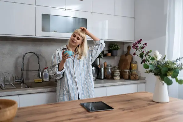 Young woman morning routine in domestic kitchen in her apartment with first coffee to wake up before she go to her work. Lifestyle of successful independent job owner.