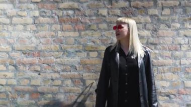 Genç, güzel, güçlü, bağımsız, asi, sarışın bir kadın. Punk müzik ve tarz hayranı pozu. Kendine güvenen Punk-Rock gençlik kültürü sokak tarzı konsepti. Havalı tavır. Farklı kavram.