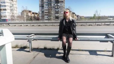 Genç, güzel, güçlü, bağımsız, asi, sarışın bir kadın. Punk müzik ve tarz hayranı pozu. Kendine güvenen Punk-Rock gençlik kültürü sokak tarzı konsepti. Havalı tavır. Farklı kavram.