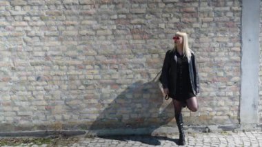 Genç, güzel, güçlü, bağımsız, asi, sarışın bir kadın. Punk müzik ve tarz hayranı pozu. Kendine güvenen Punk-Rock gençlik kültürü sokak tarzı konsepti. Havalı tavır. Farklı kavram.