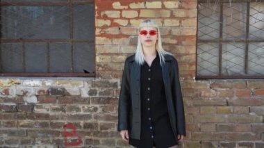 Genç, güzel, güçlü, bağımsız, asi, sarışın bir kadın. Punk müzik ve tarz hayranı pozu. Kendine güvenen Punk-Rock gençlik kültürü sokak tarzı konsepti. Havalı tavır. Farklı kavram.