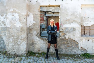 Genç, güzel, güçlü, bağımsız, asi, sarışın bir kadın. Punk müzik ve tarz hayranı pozu. Kendine güvenen Punk-Rock gençlik kültürü sokak tarzı konsepti. Havalı tavır. Farklı kavram.