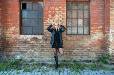 Genç, güzel, güçlü, bağımsız, asi, sarışın bir kadın. Punk müzik ve tarz hayranı pozu. Kendine güvenen Punk-Rock gençlik kültürü sokak tarzı konsepti. Havalı tavır. Farklı kavram.