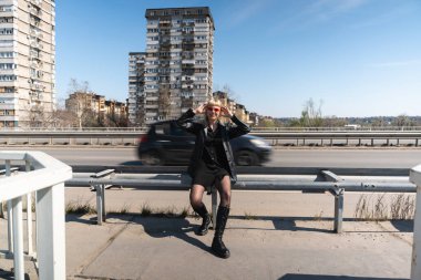 Genç, güzel, güçlü, bağımsız, asi, sarışın bir kadın. Punk müzik ve tarz hayranı pozu. Kendine güvenen Punk-Rock gençlik kültürü sokak tarzı konsepti. Havalı tavır. Farklı kavram.