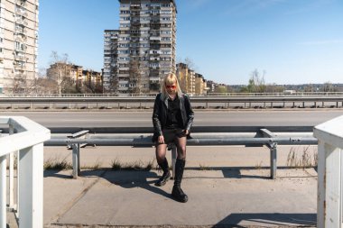 Genç, güzel, güçlü, bağımsız, asi, sarışın bir kadın. Punk müzik ve tarz hayranı pozu. Kendine güvenen Punk-Rock gençlik kültürü sokak tarzı konsepti. Havalı tavır. Farklı kavram.