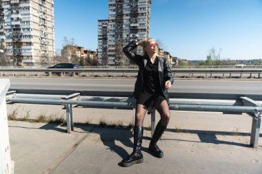 Genç, güzel, güçlü, bağımsız, asi, sarışın bir kadın. Punk müzik ve tarz hayranı pozu. Kendine güvenen Punk-Rock gençlik kültürü sokak tarzı konsepti. Havalı tavır. Farklı kavram.