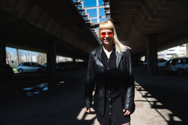 Genç, güzel, güçlü, bağımsız, asi, sarışın bir kadın. Punk müzik ve tarz hayranı pozu. Kendine güvenen Punk-Rock gençlik kültürü sokak tarzı konsepti. Havalı tavır. Farklı kavram.