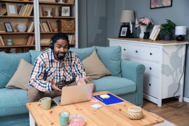 Genç Afrikalı değişim öğrencisi serbest çalışan bir iş adamı evinde oturmuş ailesiyle web kamerasından konuşuyor. Evden çalışan Afrikalı Amerikalı çevrimiçi satıcı.