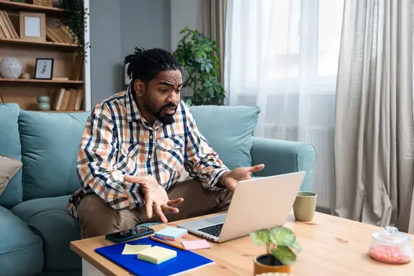 Genç Afrikalı değişim öğrencisi serbest çalışan işadamı evde oturmuş kameradan ırkçılık ve ırkçılık ile ilgili kişisel olumsuz deneyimler hakkında konuşuyor..