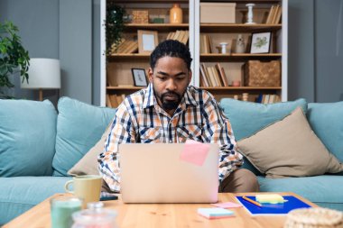 Ek iş para, ikinci iş konsepti. Öğrenci kredisini ödemek için internetten internet üzerinden çalışan genç bir üniversite öğrencisi, kira için para biriktiriyor, seyahat tatilinde ev videosundan erkek işi