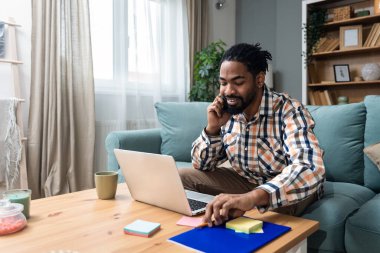 Ek iş para, ikinci iş konsepti. Öğrenci kredisini ödemek için internetten internet üzerinden çalışan genç bir üniversite öğrencisi, kira için para biriktiriyor, seyahat tatilinde ev videosundan erkek işi