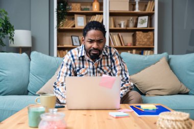 Ek iş para, ikinci iş konsepti. Öğrenci kredisini ödemek için internetten internet üzerinden çalışan genç bir üniversite öğrencisi, kira için para biriktiriyor, seyahat tatilinde ev videosundan erkek işi