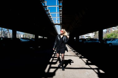 Genç, güzel, güçlü, bağımsız, asi, sarışın bir kadın. Punk müzik ve tarz hayranı pozu. Kendine güvenen Punk-Rock gençlik kültürü sokak tarzı konsepti. Havalı tavır. Farklı kavram.