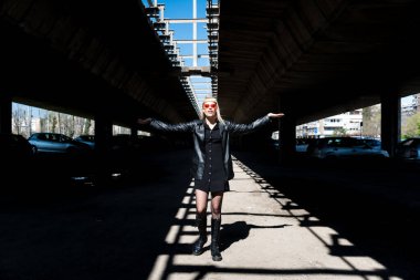 Genç, güzel, güçlü, bağımsız, asi, sarışın bir kadın. Punk müzik ve tarz hayranı pozu. Kendine güvenen Punk-Rock gençlik kültürü sokak tarzı konsepti. Havalı tavır. Farklı kavram.