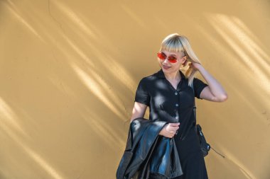 Genç, güzel, güçlü, bağımsız, asi, sarışın bir kadın. Punk müzik ve tarz hayranı pozu. Kendine güvenen Punk-Rock gençlik kültürü sokak tarzı konsepti. Havalı tavır. Farklı kavram.