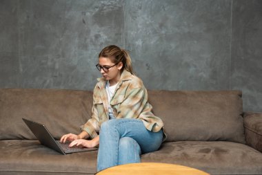 Ek iş para, ikinci iş konsepti. Öğrenci kredisini ödemek için internetten internet üzerinden çalışan genç bir üniversite öğrencisi, kira, seyahat, finans ve ekonomi videoları için para biriktiriyor.