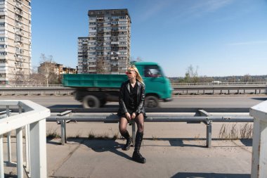 Genç, güzel, güçlü, bağımsız, asi, sarışın bir kadın. Punk müzik ve tarz hayranı pozu. Kendine güvenen Punk-Rock gençlik kültürü sokak tarzı konsepti. Havalı tavır. Farklı kavram.