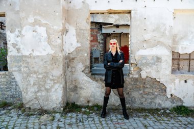 Genç, güzel, güçlü, bağımsız, asi, sarışın bir kadın. Punk müzik ve tarz hayranı pozu. Kendine güvenen Punk-Rock gençlik kültürü sokak tarzı konsepti. Havalı tavır. Farklı kavram.