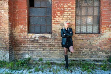 Genç, güzel, güçlü, bağımsız, asi, sarışın bir kadın. Punk müzik ve tarz hayranı pozu. Kendine güvenen Punk-Rock gençlik kültürü sokak tarzı konsepti. Havalı tavır. Farklı kavram.