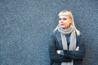 Havalı tavırları olan kendine güvenen genç bir kadının portresi. Hippi tarzı kadın siyah duvara poz veriyor..